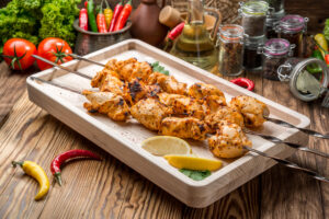 Assorted delicious grilled meat with vegetable on white plate picnic table for family bbq party