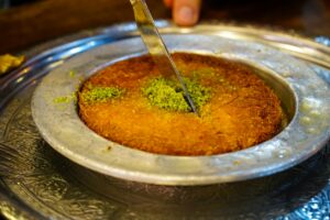Kunefe dessert, top view of traditional Turkish dessert kunefe with pistachios on top.