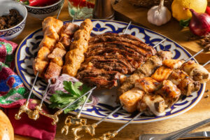A large set of different types of shish kebab on a traditional Uzbek plate.