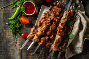 Summer Barbecue menu. Grilled meat skewers on rustic wooden tabl
